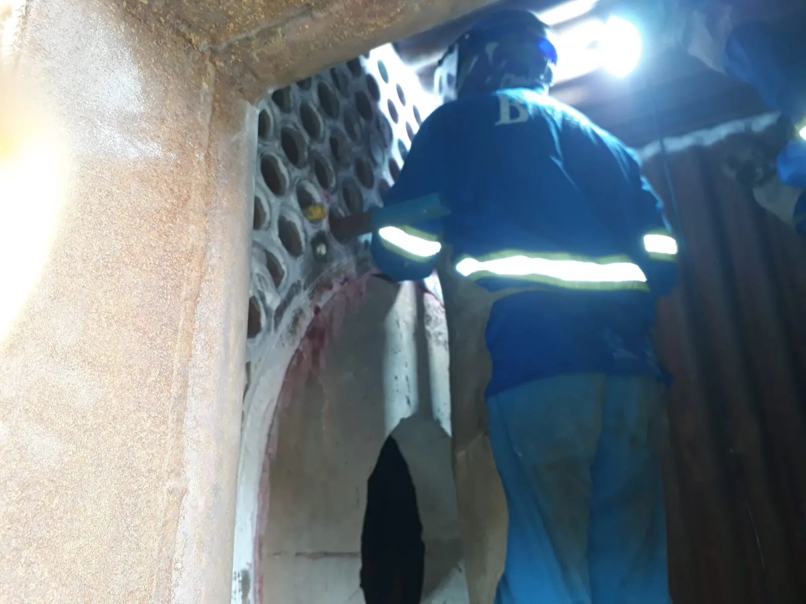 Engenheiro inspecionando interior de caldeira industrial